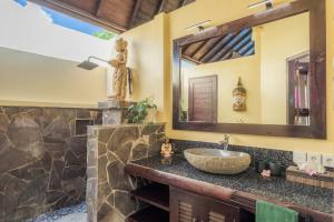 a bathroom with a sink and a mirror at Villa KaRo Pemuteran in Pemuteran +23 photos