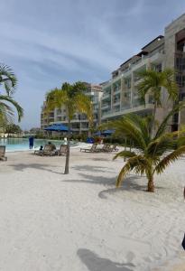 a resort on the beach with palm trees and chairs at BaiaKristal-Kabo3-3A in Cartagena de Indias