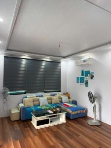 a living room with a blue couch in a room at CoNa Homestay in Ðồng Khê Sâu