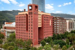 ein hohes rotes Backsteingebäude mit einem Uhrturm in der Unterkunft Meliá Bilbao in Bilbao