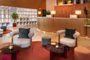 Eine Hotellobby mit zwei Stühlen und einem Tresen in der Unterkunft Meliá Bilbao in Bilbao