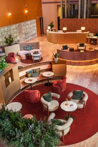 eine Hotellobby mit Tischen und Stühlen und einem Warteraum in der Unterkunft Meliá Bilbao in Bilbao