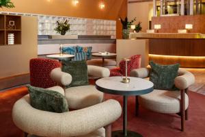 ein Wartebereich mit Stühlen und Tischen in einem Restaurant in der Unterkunft Meliá Bilbao in Bilbao + 69 Fotos