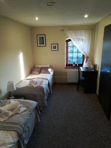 a room with two beds and a desk and a window at Młyn in Chodecz