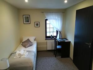 a bedroom with a bed and a desk and a window at Młyn in Chodecz