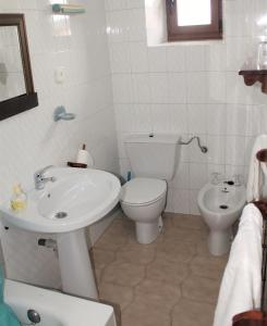 a white bathroom with a toilet and a sink at Apartamentos Maite in Oreña +32 photos