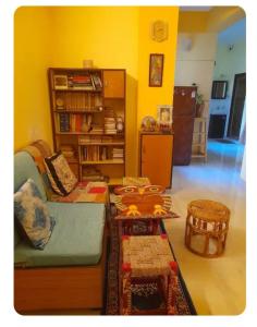a living room with a couch and a book shelf at Sir Residency in Howrah