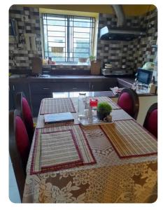 a kitchen with a table and chairs with a tableablish at Sir Residency in Howrah