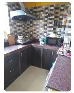 a kitchen with a counter top and a microwave at Sir Residency in Howrah