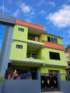 a colorful building with people on a balcony at Lama home in Bālāju