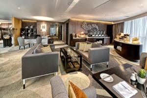 a living room with couches and chairs and a table at Meliá Makassar in Makassar