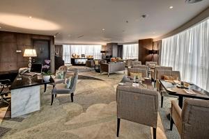 a living room with chairs and tables and a lobby at Meliá Makassar in Makassar