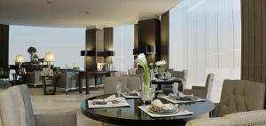 a dining room with a table and chairs at Meliá Makassar in Makassar