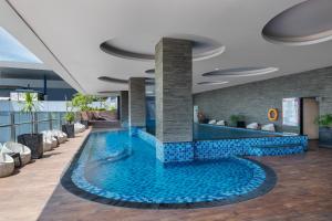 a swimming pool in a hotel lobby at Meliá Makassar in Makassar +24 photos