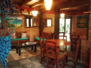 a dining room with a wooden table and chairs at Pousada Além do Jardim in Praia do Rosa