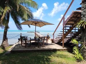a table with an umbrella next to the beach at Boraha Village Ecolodge in Ambodifototra