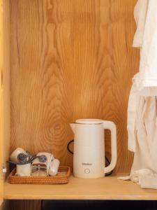 a coffee maker and other items on a shelf at Hani Boutique Hotel Phú Quý in Cù Lao Thu