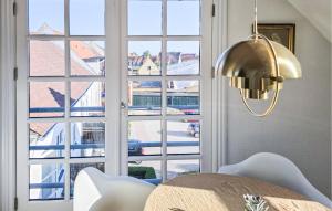 a dining room with a table and a large window at 2 Bedroom Nice Apartment In Faaborg in Faaborg