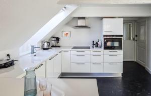 a white kitchen with white cabinets and a staircase at 2 Bedroom Nice Apartment In Faaborg in Faaborg