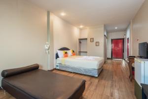 a bedroom with a bed and a couch in a room at BKK39 Airport Hotel in Lat Krabang