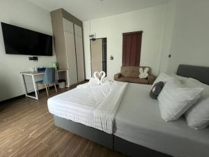 a bedroom with a large white bed and a desk at AlinApartment in Ban Sa Kruat