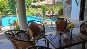 a patio with a table and chairs and a pool at Machan Villa in Tangalle