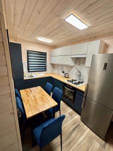 a kitchen with a wooden table and a refrigerator at Osada Leonówka in Leonów