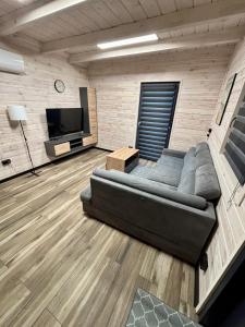 a living room with a couch and a flat screen tv at Osada Leonówka in Leonów