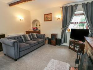 a living room with a couch and a tv at West End House in Bradford