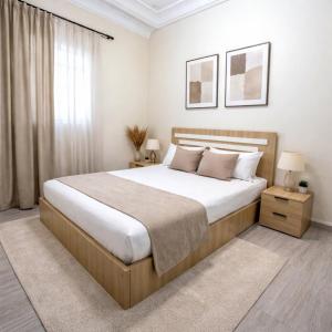 a bedroom with a large bed and two night stands at Spacious Apartment with Motorcycle Garage, Free Parking, and Air Conditioning in Er Rachidia