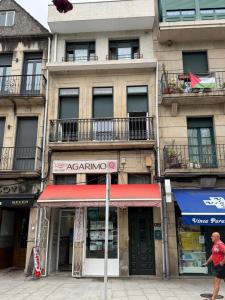 a man walking past an apartment building with balconies at Rubín 21 in Redondela