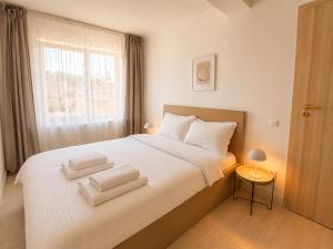 a bedroom with a white bed with towels on it at DD Apartments - Iuliu Moldovan in Cluj-Napoca
