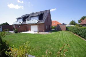 a house with a large lawn in front of it at Am-Nordmeerstrand in Norddeich