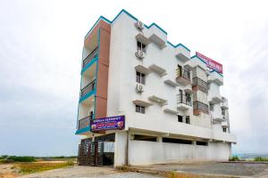 a tall white building with a sign on it at Subham Residency in Chennai +29 photos