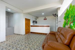 a living room with a leather couch and a waiting room at Subham Residency in Chennai