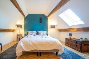 a bedroom with a large bed and a skylight at Le Chai des Écluses 4-étoiles gîtes in Saint-Léger-sur-Dheune