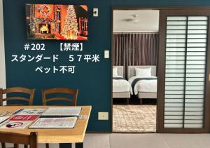 a room with a dining table and a bedroom at SakuraPiso in Kagoshima