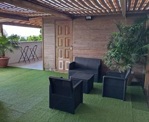 a patio with two chairs and a table and plants at Lodge de Charme Vue Imprenable in Le Robert