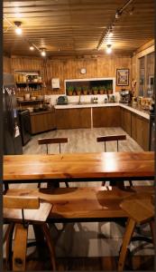 a kitchen with a large wooden table with two benches at Hostal Casa Trancura in Pucón