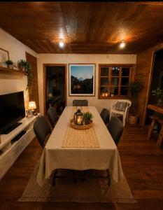 a dining room with a table with chairs and a television at Hostal Casa Trancura in Pucón +9 photos