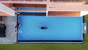 an overhead view of a person swimming in a pool at River Bay Athirappilly in Athirappilly