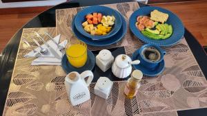 a table with two blue plates of food and fruit at Casa Hotel Imperion in Bogotá