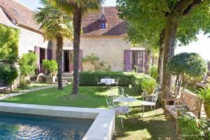 une maison avec une piscine, une table et des chaises dans l'établissement La Devinie, à Martel