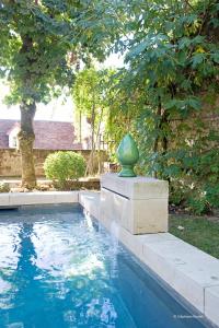 une fontaine avec un vase vert au milieu d'une piscine dans l'établissement La Devinie, à Martel