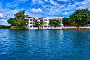 a white building on the side of a body of water at Centauria Lake Resort in Embilipitiya