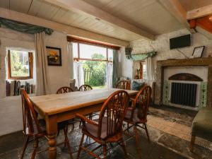 a dining room with a wooden table and chairs at Moldy Warp Barn in Keighley