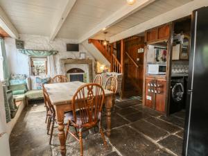 a kitchen with a table and chairs and a fireplace at Moldy Warp Barn in Keighley