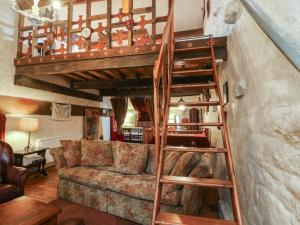 a living room with a loft bed and a couch at Moldy Warp Barn in Keighley