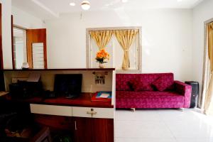 a living room with a pink couch and a window at Hotel green hills in Waki +9 photos