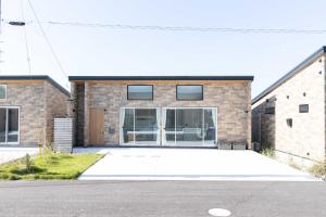 a brick house with a driveway in front of it at ウミチカ in Minamiboso